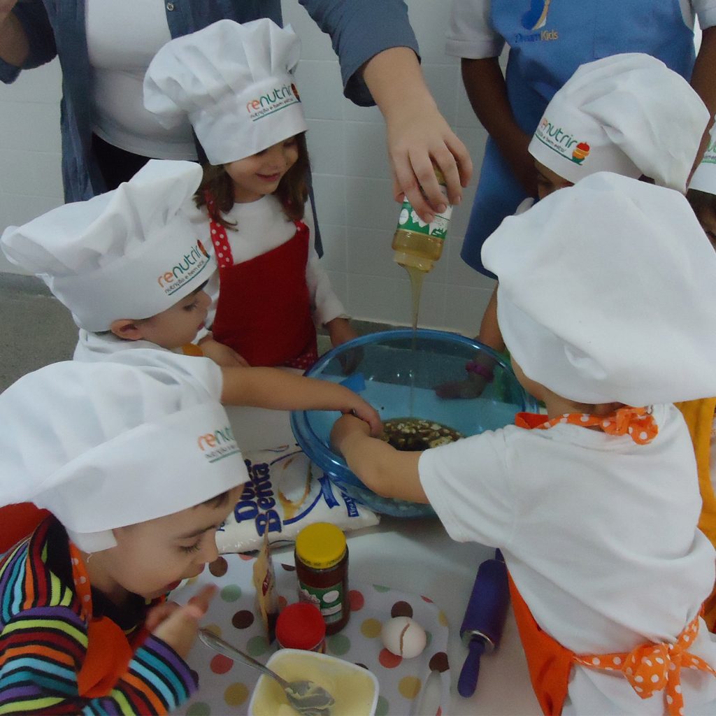Em atividade extracurricular de culinária, crianças misturam ingredientes